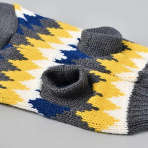 Stretchy dog sweater that has a pretty jagged multicolored design of gray, white, yellow, and blue alternately.