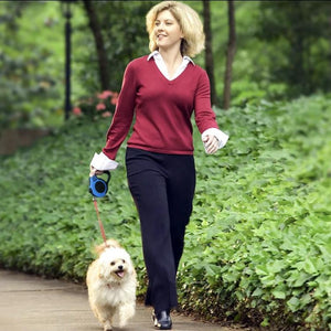 A Woman Walking With A Dog On A Blue Retractable Leash